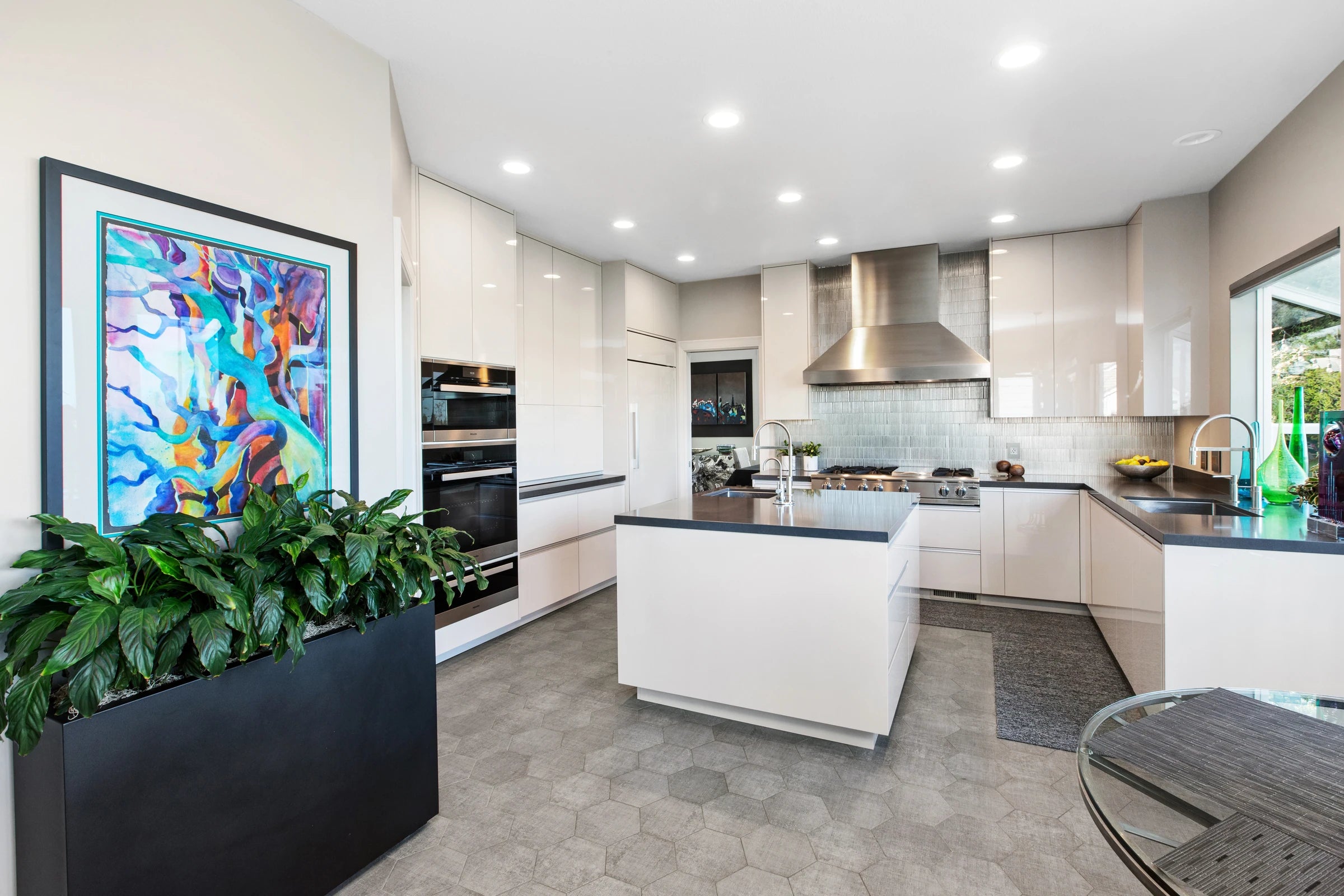 Glossy white custom kitchen cabinets with dark worktops and a central island